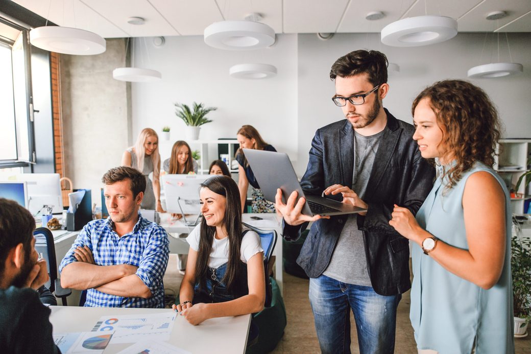 Team bespricht den Projektfortschritt gemeinsam am Laptop